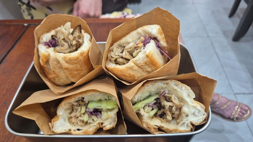Banh mi sandwiches filled with mushrooms, cucumber and shredded vegetables.