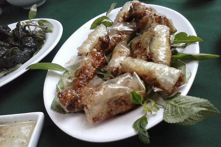 Golden fried rolls served with fresh herbs at a Le Mat Village restaurant.