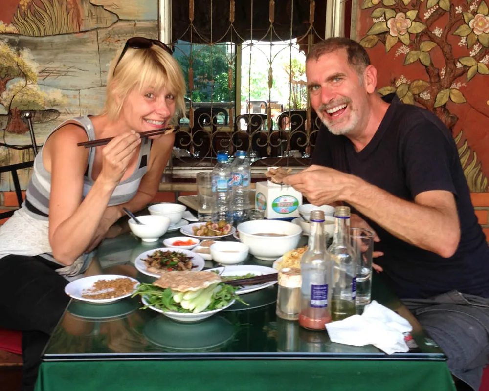 Two visitors enjoying local food together at a Le Mat Village restaurant.